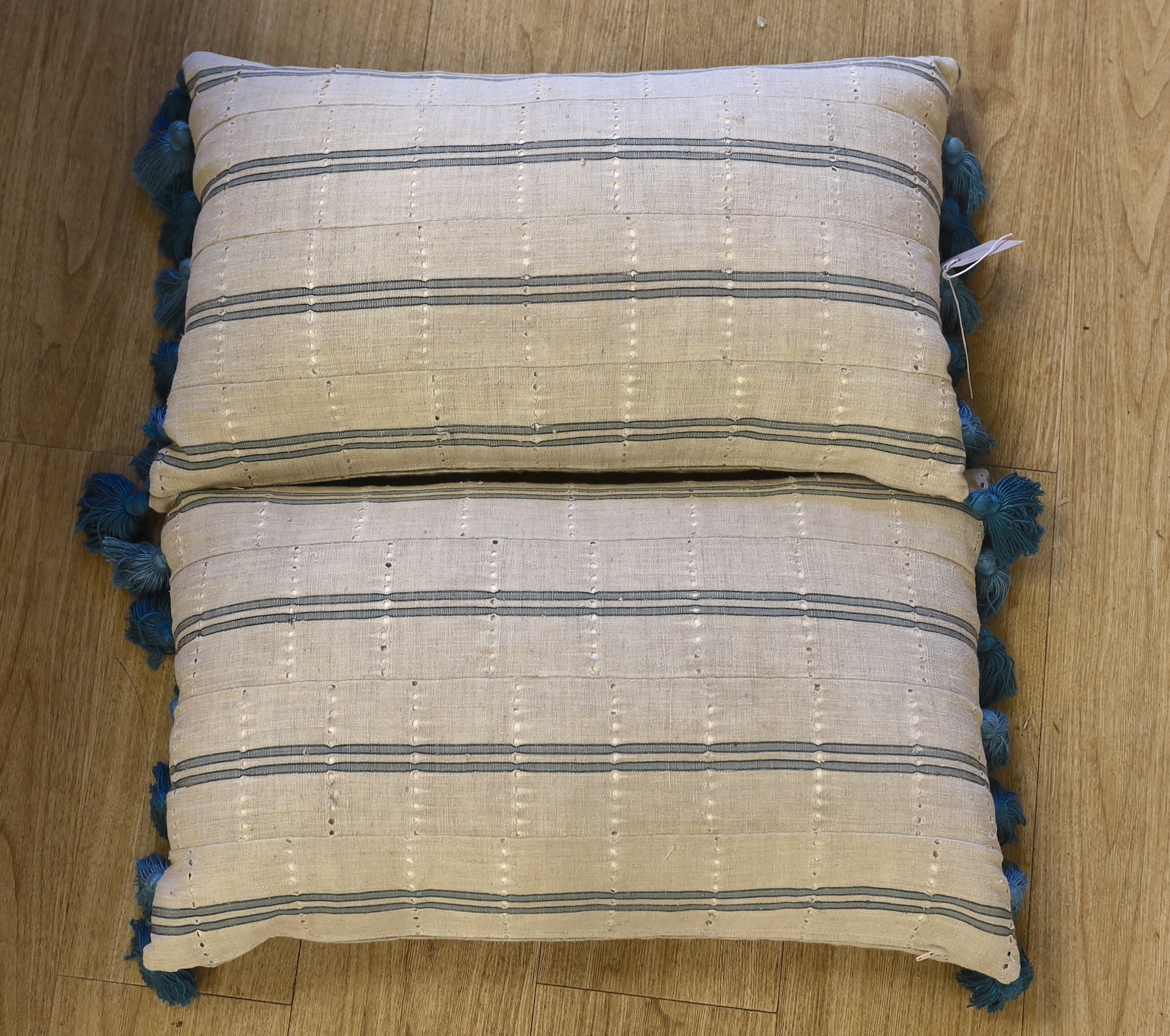 A pair of vintage Yoruba cushions with bamboo tassels, each 65cm wide